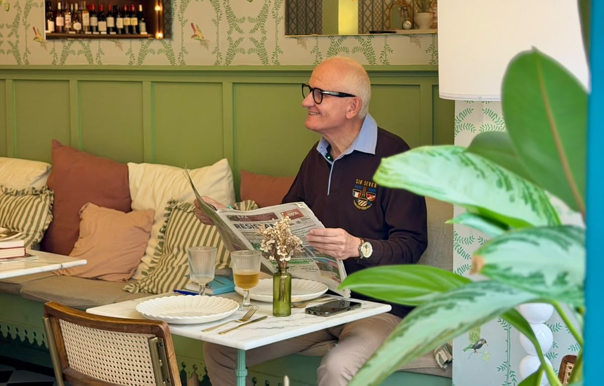 Lecture du journal sur la banquette du salon de thé du Comptoir