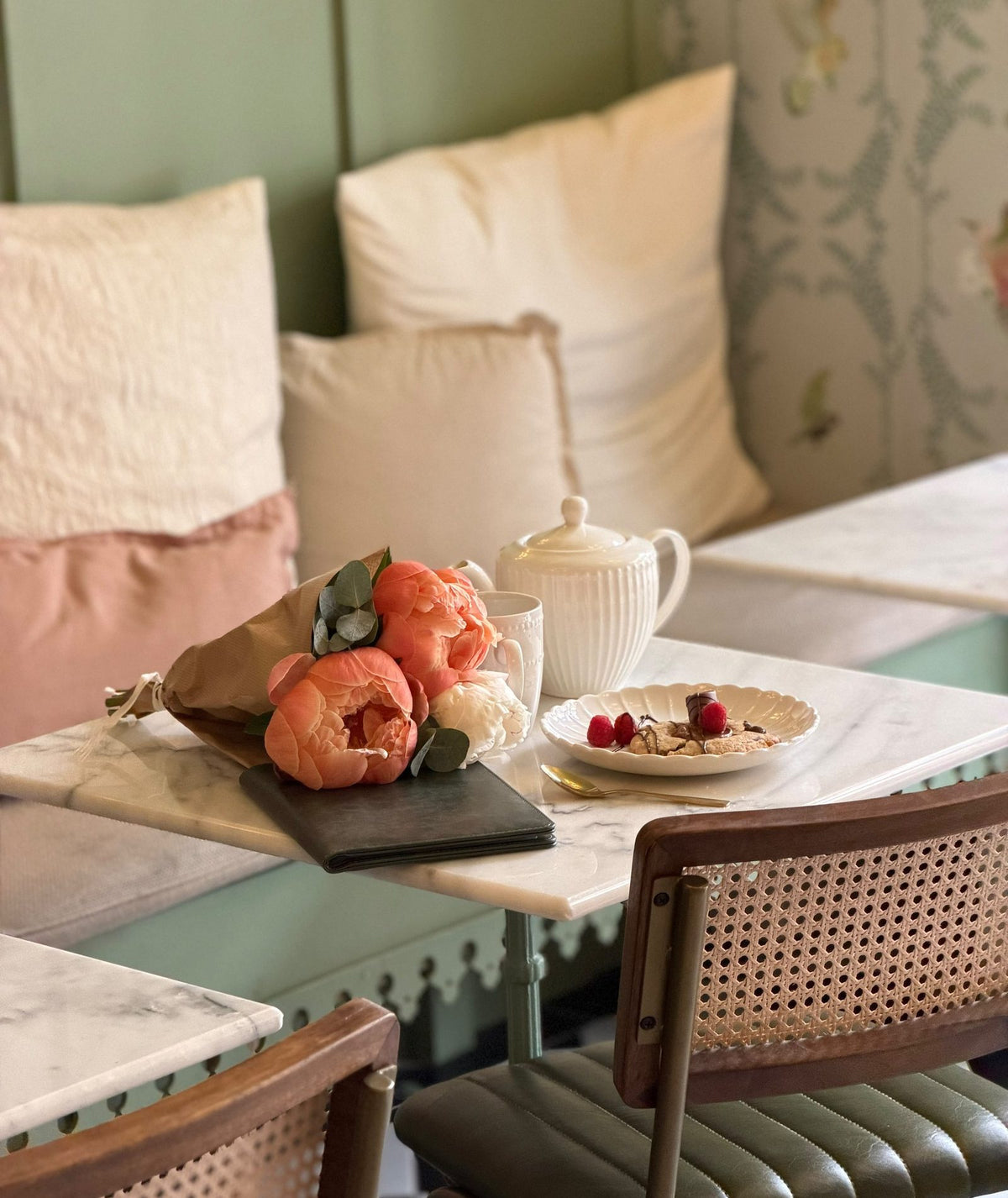 Thé, fleurs et dessert sur une table de marbre