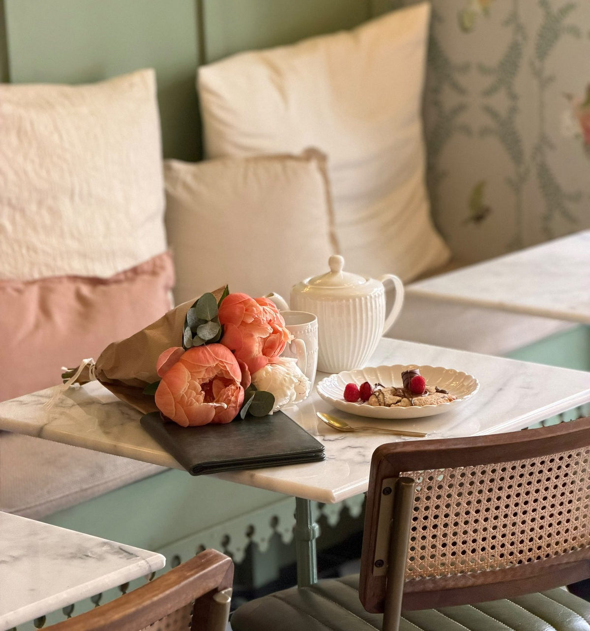 Thé, fleurs et dessert sur une table de marbre