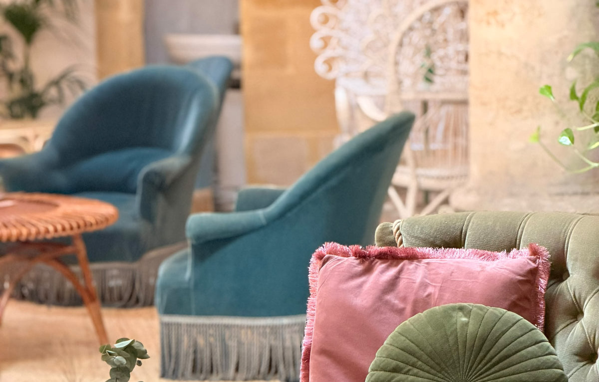 Fauteuils bleus et coussins velours du salon
