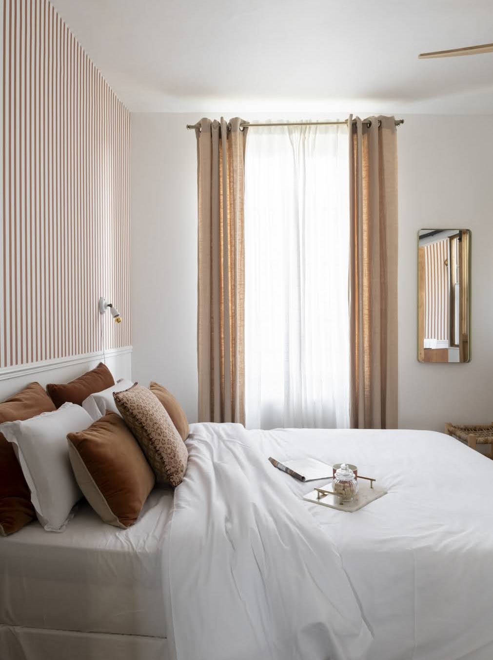 Chambre du Pavillon, lit blanc, coussins terracotta et tête de lit rayée rose