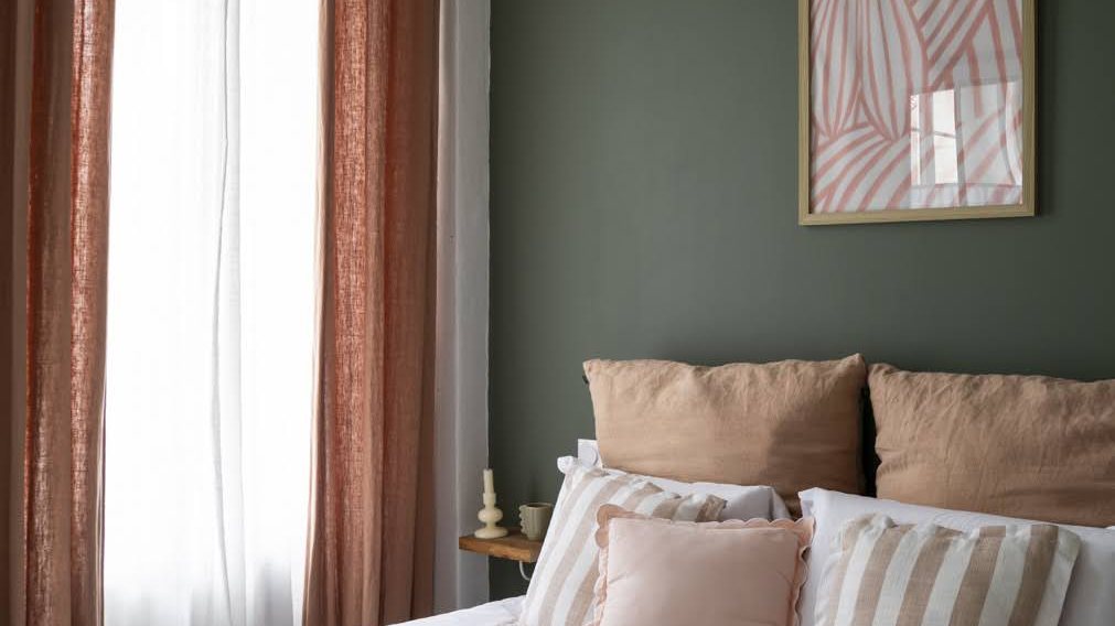 Chambre du Pavillon, mur vert sauge, lit blanc et rideaux terracotta