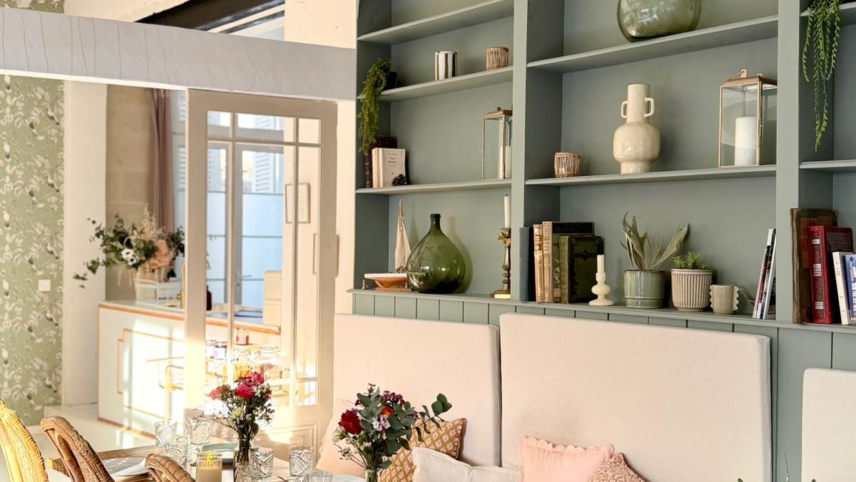 Grande salle du Pavillon, longue table dressée et étagères voûtées vert sauge