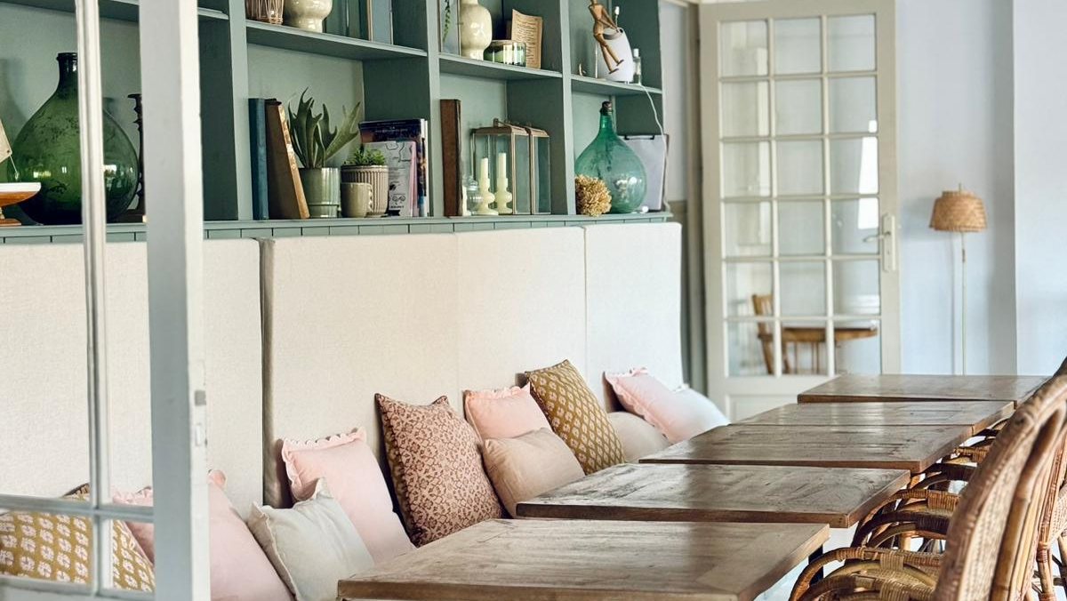 Grande salle du Pavillon, banquette et tables en bois sous les étagères voûtées