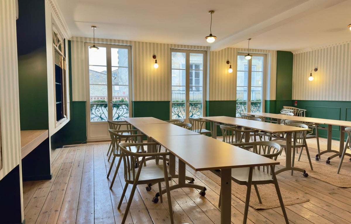 Le Haut Comptoir, la grande salle de l'étage, tables en U et bibliothèque verte