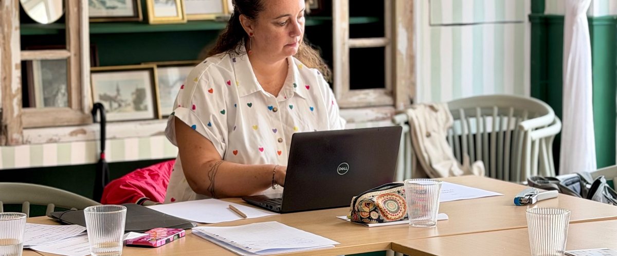 Open space du Comptoir : une coworkeuse à son ordinateur à la grande table en bois clair