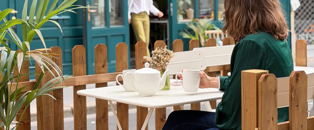 Terrasse du Comptoir : thé servi sur une table blanche devant la façade bleu canard
