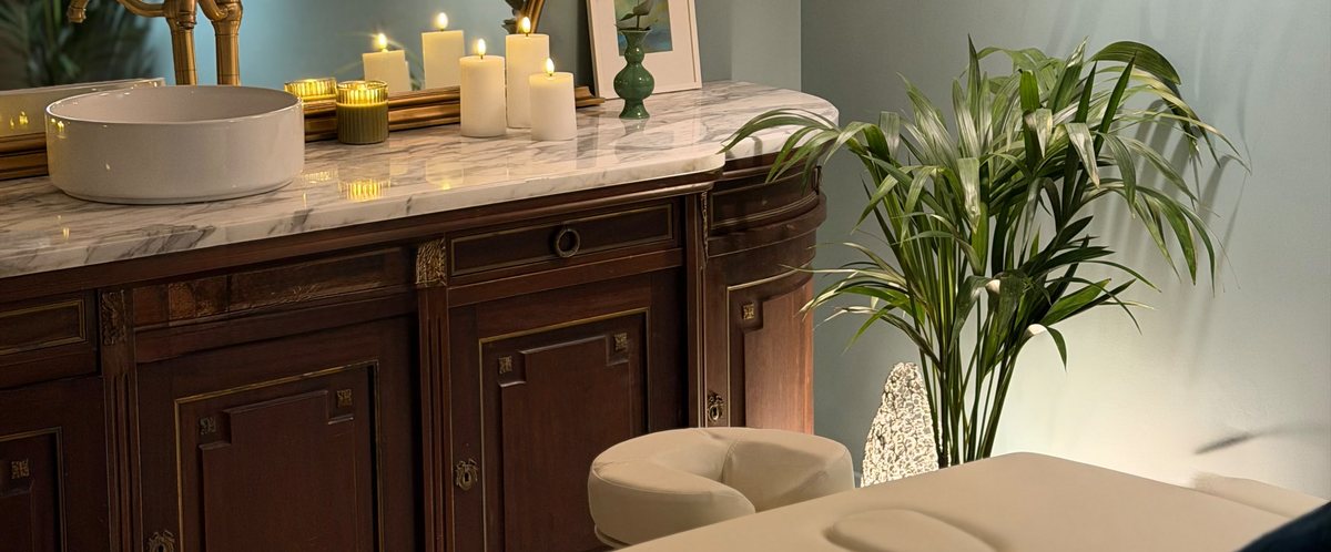 Cabine bien-être Sémillon : meuble en bois, vasque en marbre, bougies et table de massage
