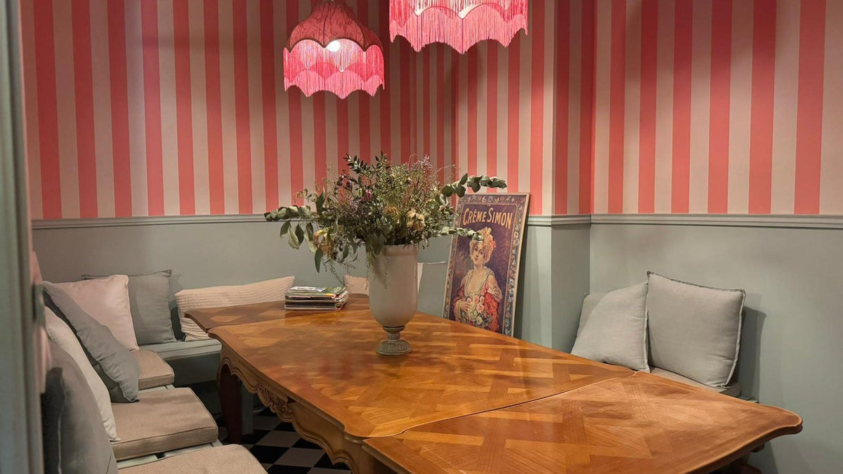 Salle de réunion Saint-Émilion, murs rayés roses et grande table en bois